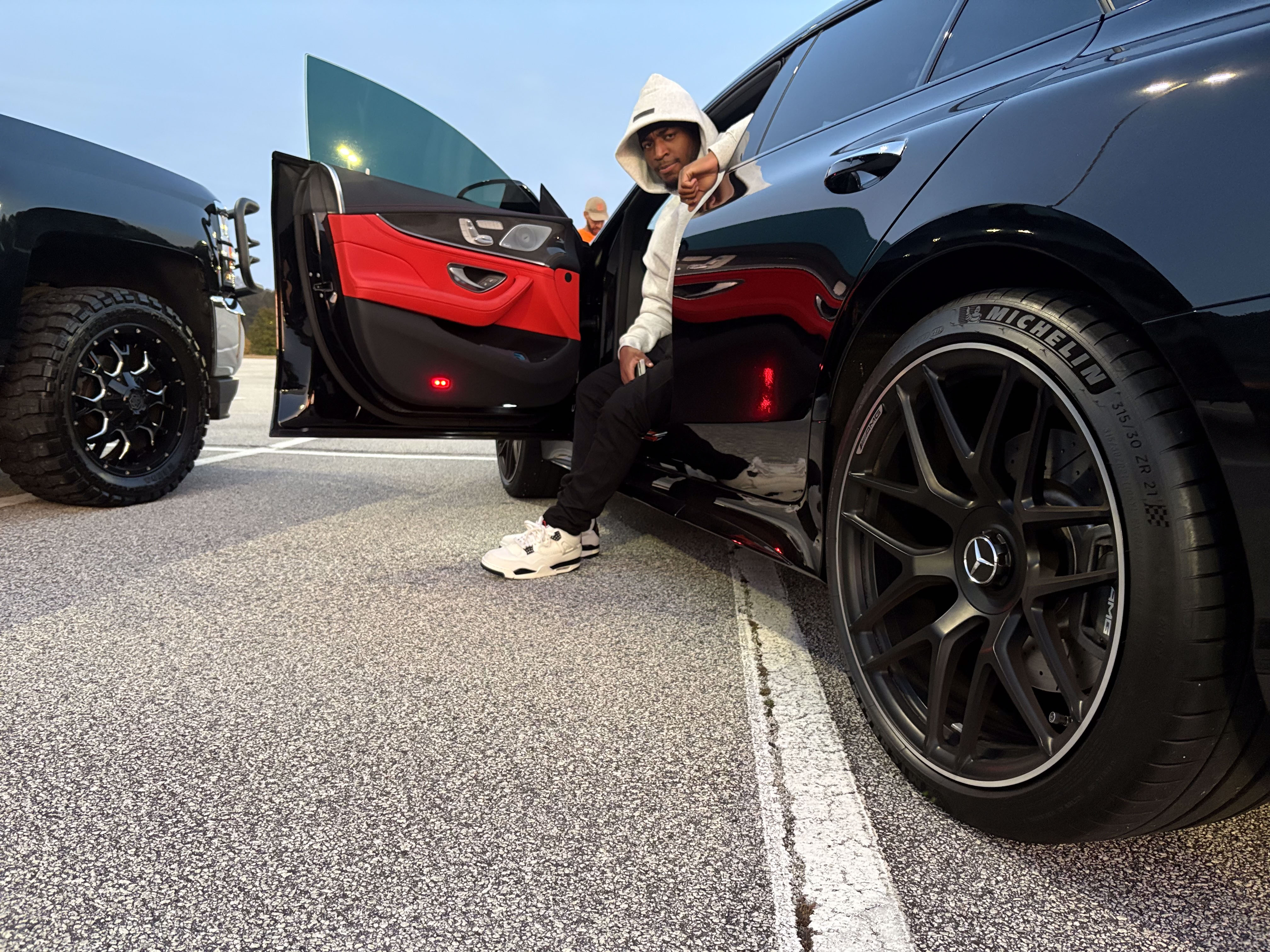 Benji posing with luxury Mercedes red interior